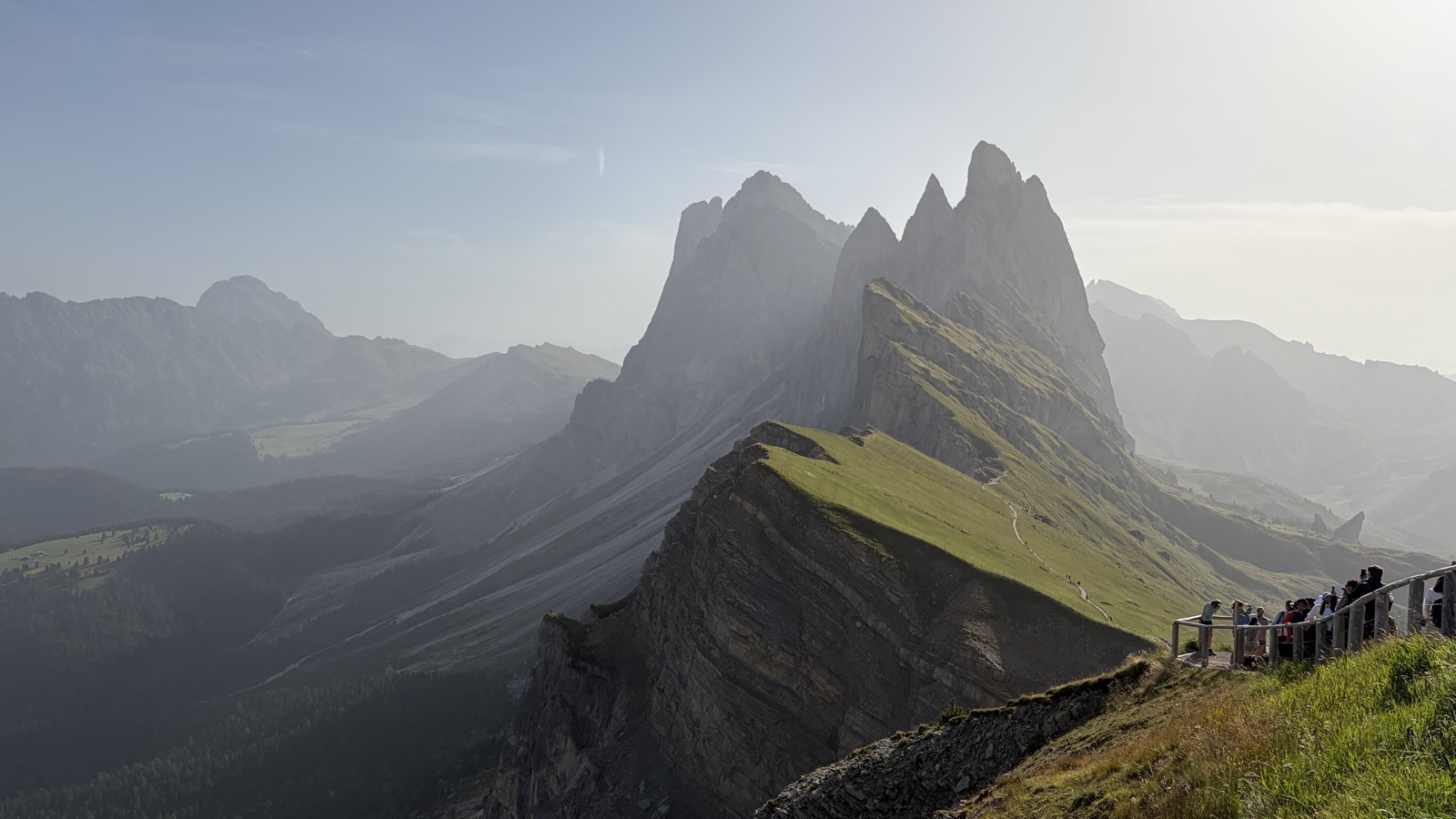 Seceda ridgeline in the Dolomites, grassy slopes dropping into a hazy valley
